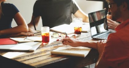 Menschen im Büro mit Getränk am Laptop