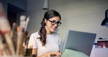 Frau arbeitet an einem Schreibtisch mit einem Laptop